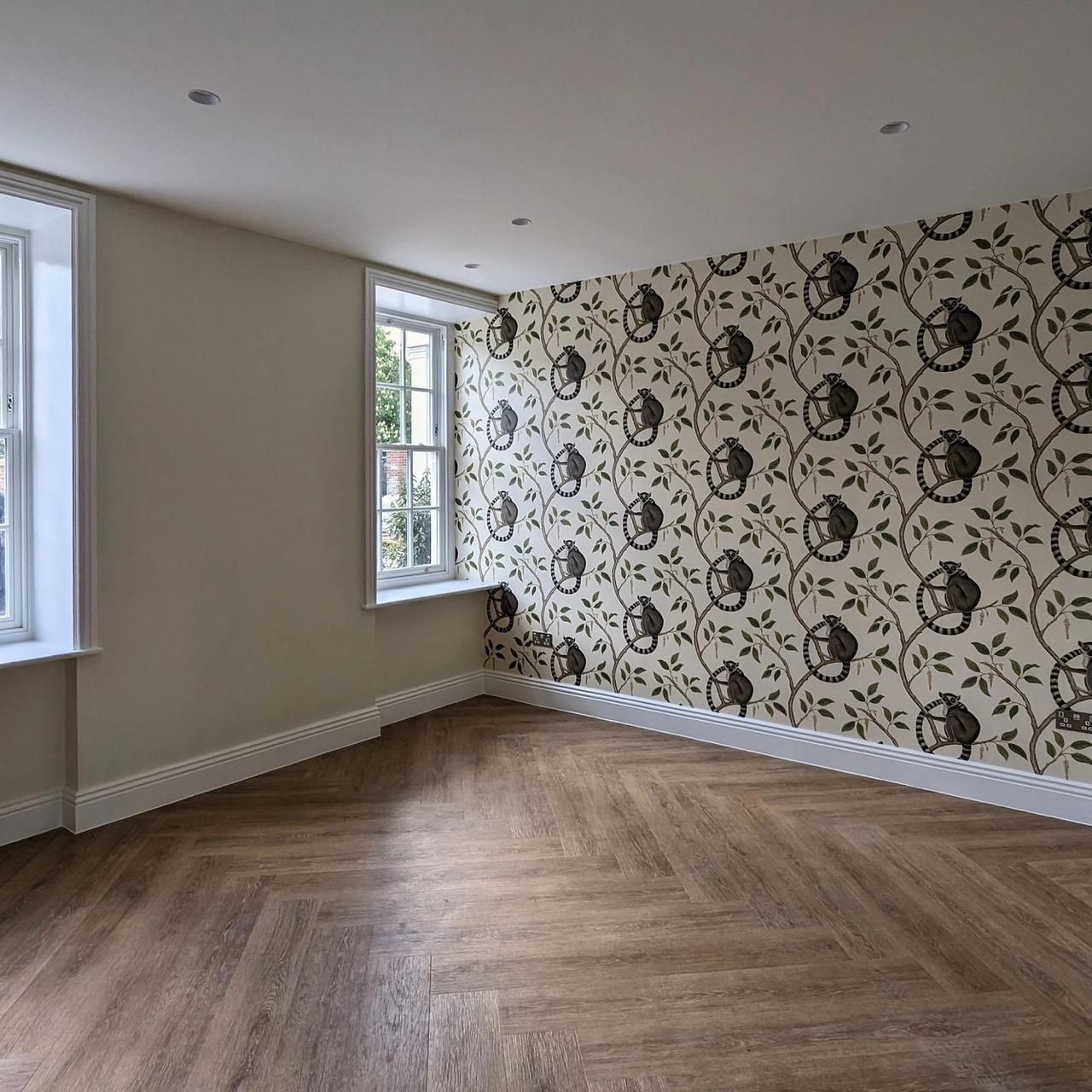 Playroom with a botanical feature wallpaper on the end wall, sash windows and a herringbone floor
