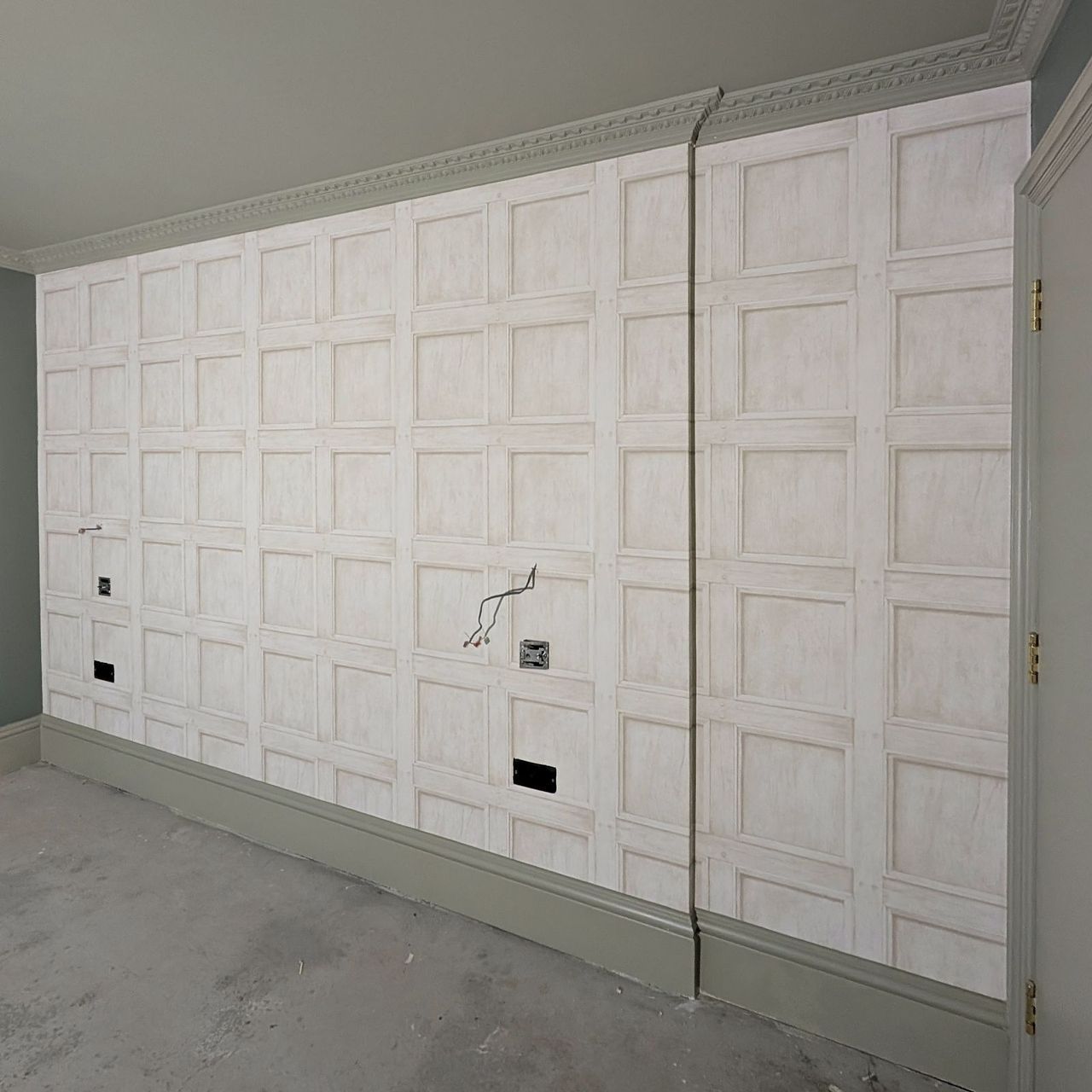 The same feature wall seen across its full width, with pale sage walls to either side and cornice above