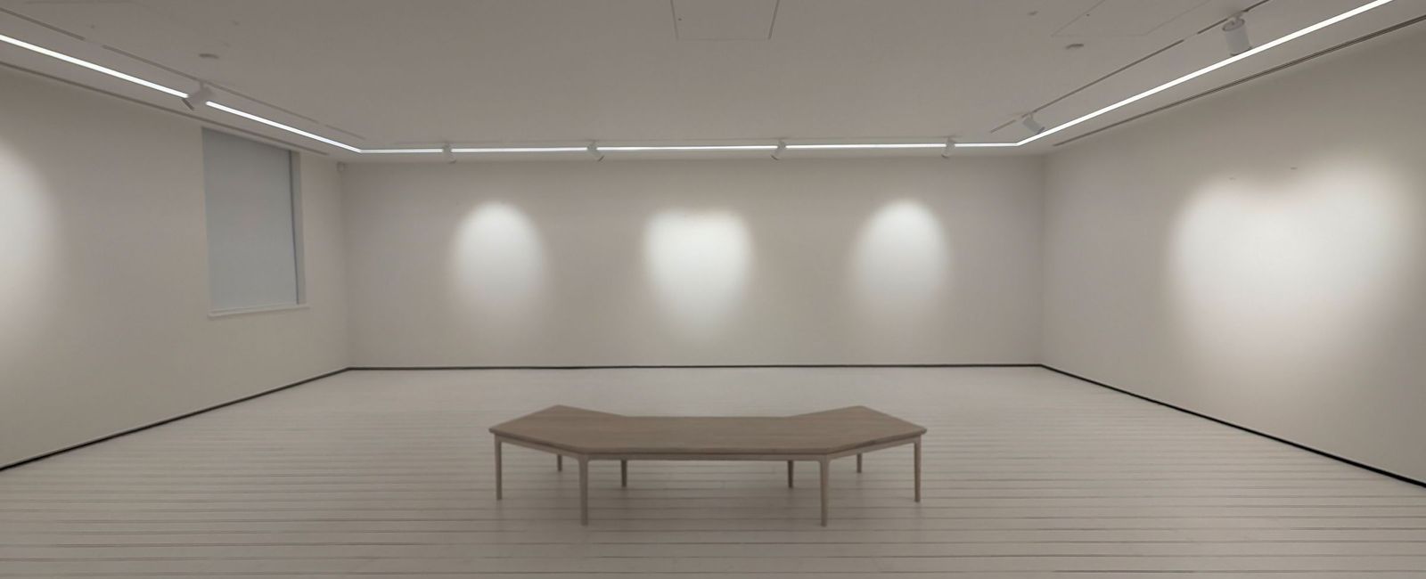 The upper gallery in white with a painted boarded floor and recessed linear lighting to the ceiling perimeter